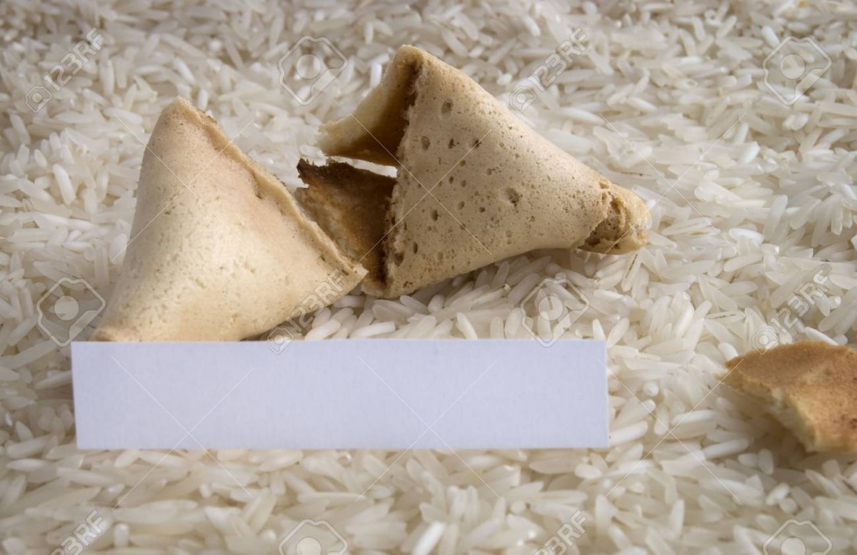 An Opened Fortune Cookie On A Bed Of White Rice Stock Photo